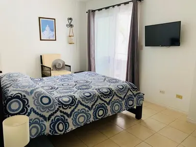 a bedroom with a bed and a tv and a window at Villa Verde II #30 in Tamarindo