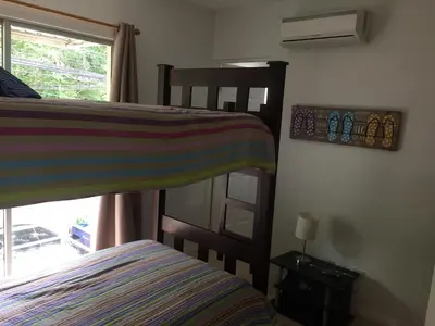 a bedroom with two bunk beds and a window at Villa Verde II #30 in Tamarindo