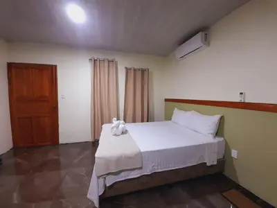 a bedroom with a white bed with a towel on it at Cabaña Rural Pura Vida in Fortuna