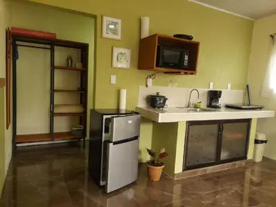 a small kitchen with a refrigerator and a sink at Cabaña Rural Pura Vida in Fortuna