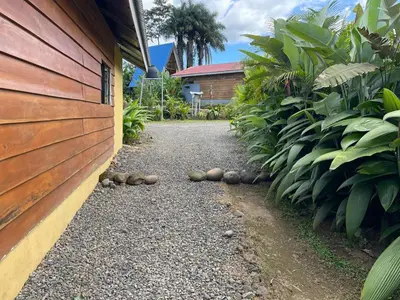 a gravel path next to a house with a building at Cabaña Rural Pura Vida in Fortuna