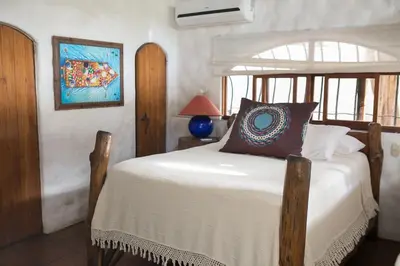 a bedroom with a bed with a white bedspread at Sueño del Mar Beachfront Hotel in Tamarindo