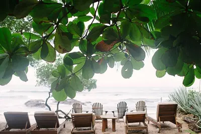 a group of chairs and a table and a group of tables and chairs at Sueño del Mar Beachfront Hotel in Tamarindo