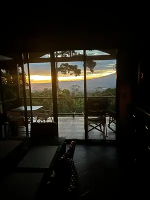 a room with a view of the sunset from a house at Bromelia House in San Gerardo