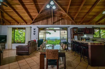 a kitchen and living room with a table and chairs at Bromelia House in San Gerardo