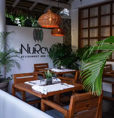 a restaurant with wooden tables and potted plants at Vayu Retreat Villas in Coronado