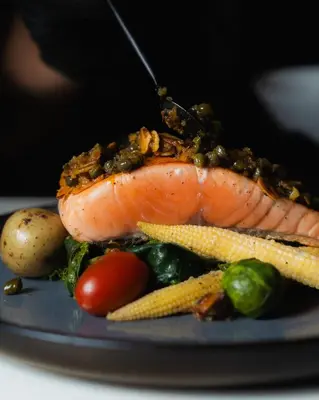 a plate of food with a piece of fish and vegetables at Vayu Retreat Villas in Coronado
