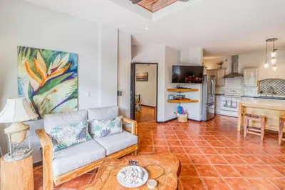 a living room with a couch and a kitchen at Casa Mimosa in Playa Flamingo