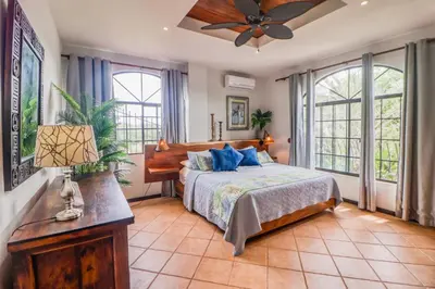 a bedroom with a bed and a ceiling fan at Casa Mimosa in Playa Flamingo