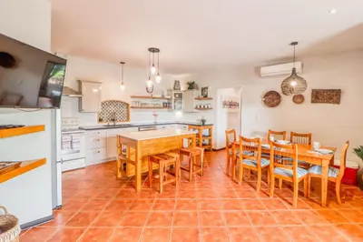 a kitchen with a table and chairs and a kitchen with white cabinets at Casa Mimosa in Playa Flamingo