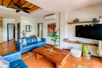 a living room with a blue couch and a table at Casa Mimosa in Playa Flamingo