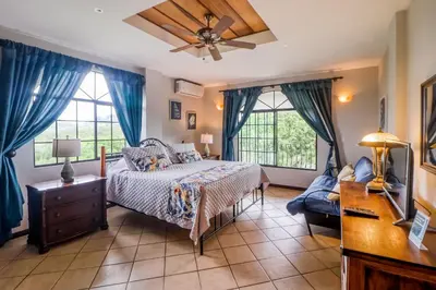 a bedroom with a bed and a ceiling fan at Casa Mimosa in Playa Flamingo