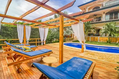 a patio with chairs and a swimming pool at Casa Mimosa in Playa Flamingo