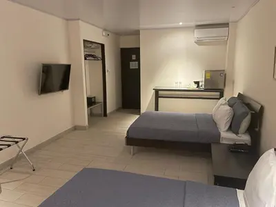 a hotel room with a bed and a tv at LOP Inn San Jose Aeropuerto - Costa Rica in Ciudad Cariari