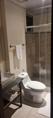 a bathroom with a toilet and a sink and a shower at LOP Inn San Jose Aeropuerto - Costa Rica in Ciudad Cariari