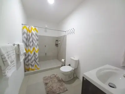 a white bathroom with a toilet and a sink at W's Hostel in San José