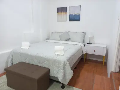 a small bedroom with a bed and a ottoman at W's Hostel in San José