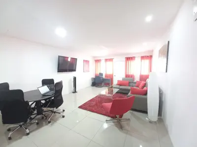 a living room with a couch and a table and chairs at W's Hostel in San José