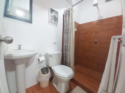 a bathroom with a toilet and a sink and a shower at W's Hostel in San José