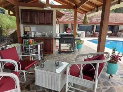 a patio with chairs and a grill and a pool at Bungalows Sanlaz in Barrio Jesús