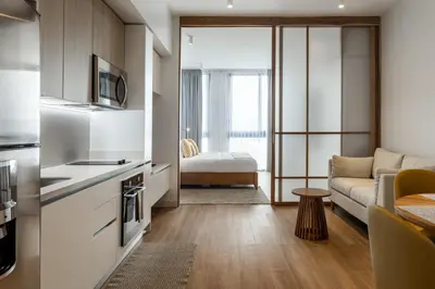 a small kitchen and living room with a couch at Residencias Cityzen cerca del Aeropuerto in Echeverría