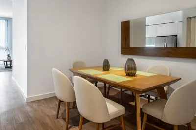 a dining room with a wooden table and chairs at Residencias Cityzen cerca del Aeropuerto in Echeverría