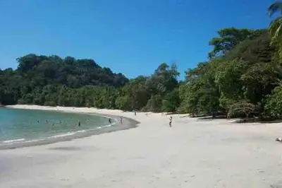 a beach with a group of people in the water at Lovely 2-BDroom Condo in Laguna Eco Village Resort in Quepos