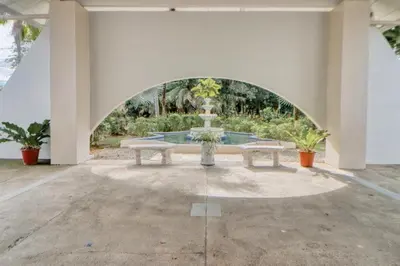a fountain in the middle of a building with two benches at Lovely 2-BDroom Condo in Laguna Eco Village Resort in Quepos