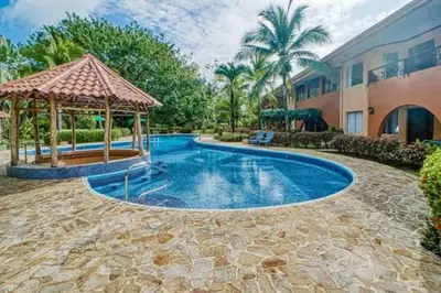 a swimming pool with a gazebo next to a building at Lovely 2-BDroom Condo in Laguna Eco Village Resort in Quepos