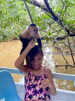 a little girl with a monkey on her head at Lovely 2-BDroom Condo in Laguna Eco Village Resort in Quepos