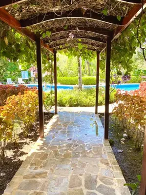 a stone walkway under a pergola in a garden at Lovely 2-BDroom Condo in Laguna Eco Village Resort in Quepos