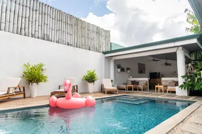 a pool with a pink inflatable flamingo in a backyard at Hotel Por Qué No in Uvita