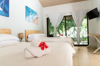 a hotel room with two beds with towels on them at Hotel Por Qué No in Uvita