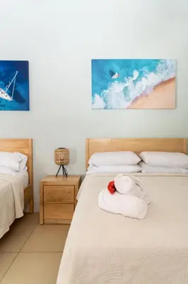 a bedroom with two beds with towels on them at Hotel Por Qué No in Uvita