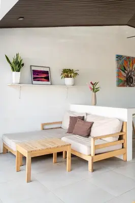 a bed and a bench in a room at Hotel Por Qué No in Uvita