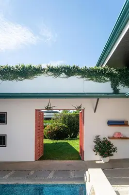 an open door to a backyard with a swimming pool at Hotel Por Qué No in Uvita