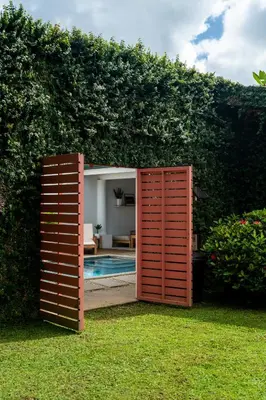 an open gate leading into a backyard with a pool at Hotel Por Qué No in Uvita