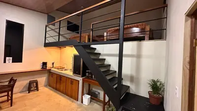 a loft bed with a staircase in a room at Modern Loft inside a beautiful farm in General Viejo