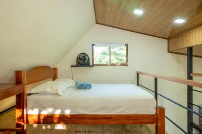 a bedroom with a bed and a window in a attic at Modern Loft inside a beautiful farm in General Viejo