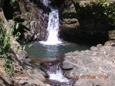 a waterfall in the middle of a pool of water at Casa Altamar in Jacó