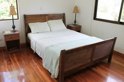 a bedroom with a large bed with two night stands at Casa Altamar in Jacó