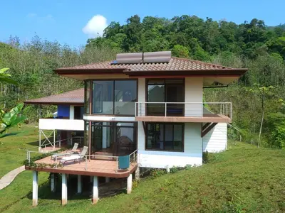 a house on a hill with a large deck at Casa Altamar in Jacó
