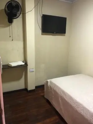 a bedroom with a bed and a tv on the wall at #2 private room close to airport in Alajuela City