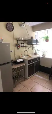 a kitchen with a sink and a refrigerator and a table at #2 private room close to airport in Alajuela City