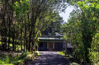 a house in the middle of a road with trees at Los Pinos Cabins & Reserve in Monteverde Costa Rica