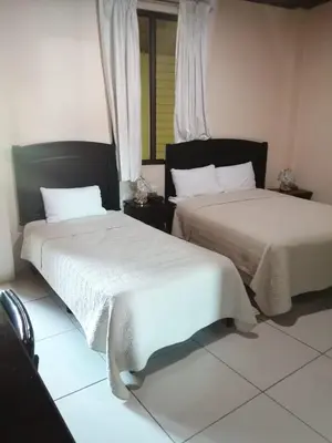 two beds sitting next to each other in a room at Hotel La Guaria in Liberia