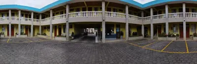 a large white building with a large courtyard at Hotel La Guaria in Liberia