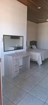 a room with a bed and a tv on the wall at Hotel La Guaria in Liberia