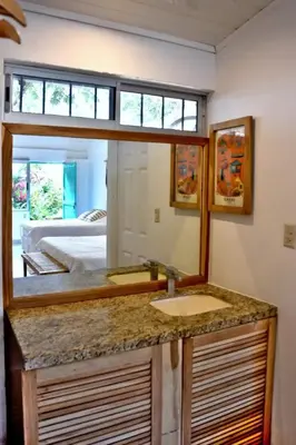 a bathroom with a sink and a mirror at Refugio Surf Lodge in Tamarindo