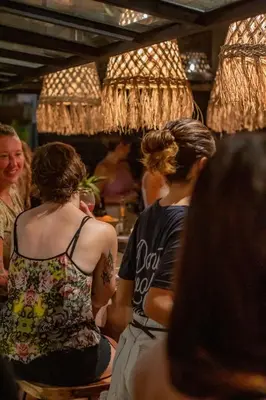 a group of people sitting around a bar at Refugio Surf Lodge in Tamarindo